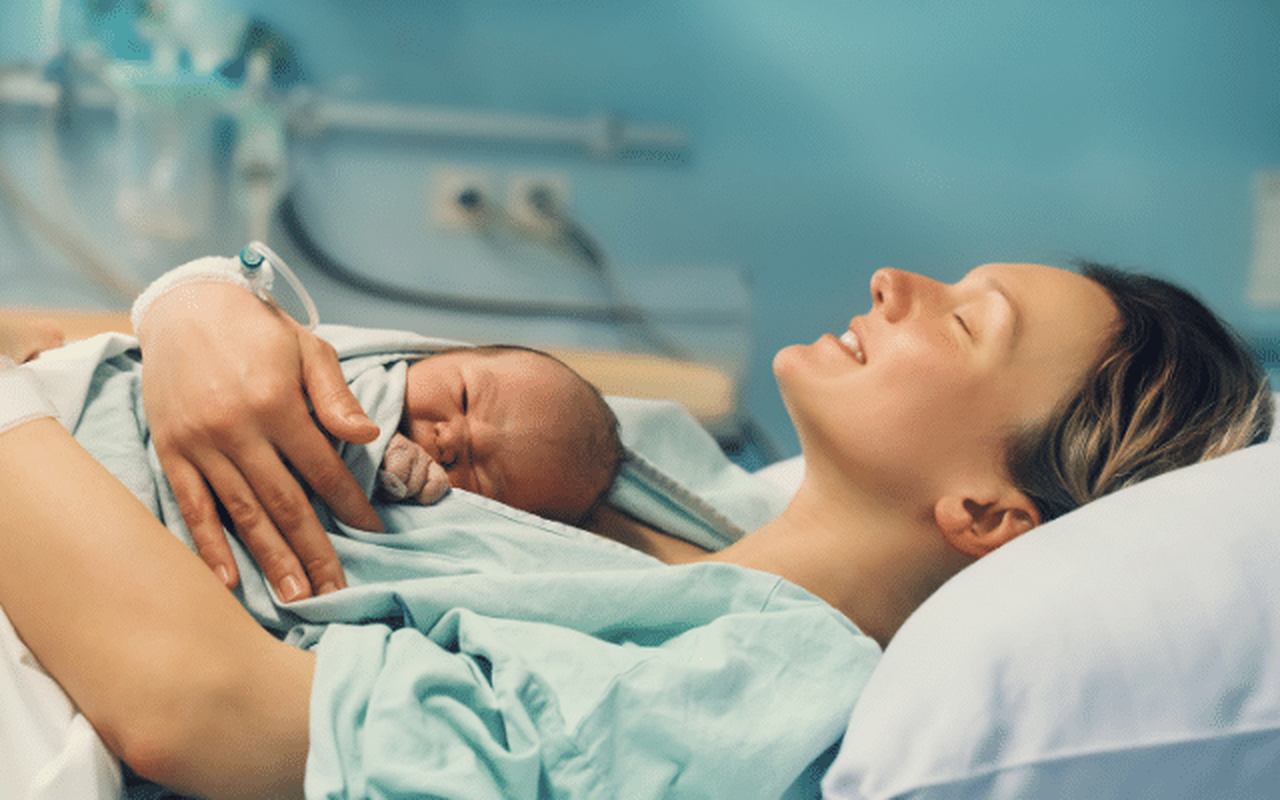 Imagem de um bebe recém-nascido deitado em cima da mãe